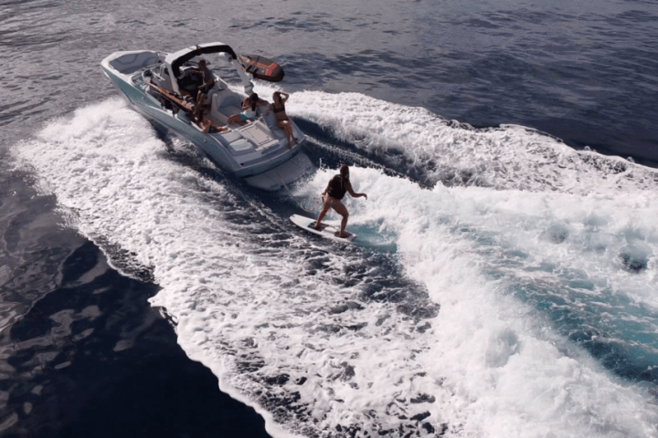 a man riding on the back of a boat in the water