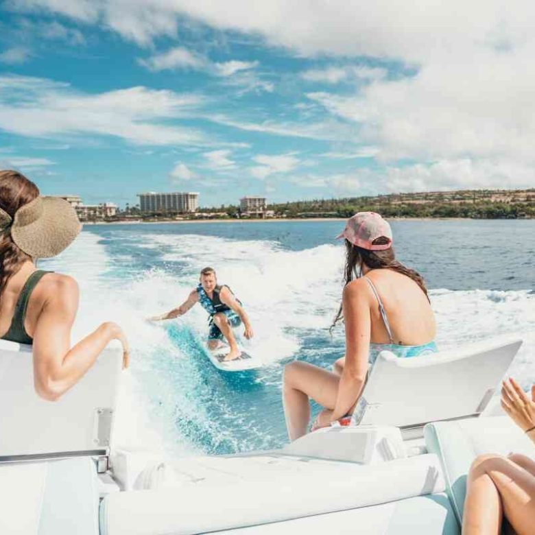 a woman sitting next to a body of water
