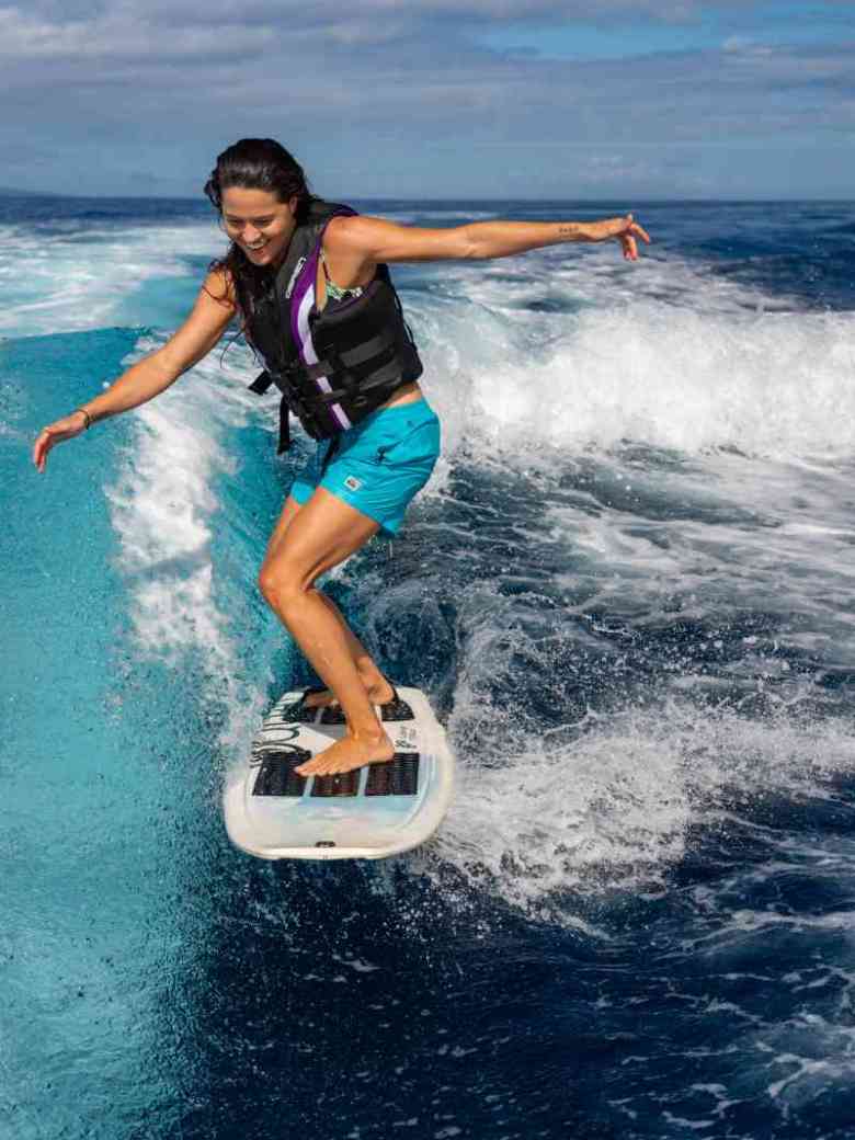 wakeboarding2 a young girl riding a wave on a surfboard in the water